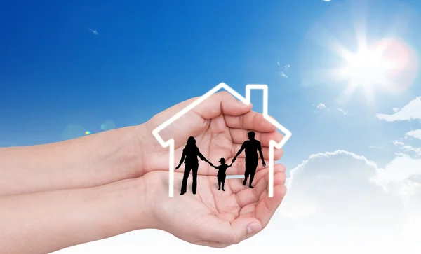 Hand with the silhouettes of the family and house — Stock Photo, Image