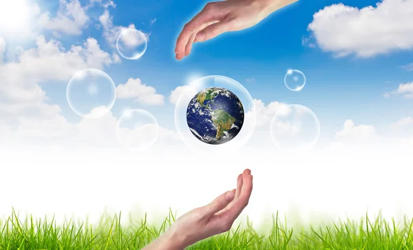 Эко-концепция: Рука держит земной шар в пузырьках против солнца и — стоковое фото