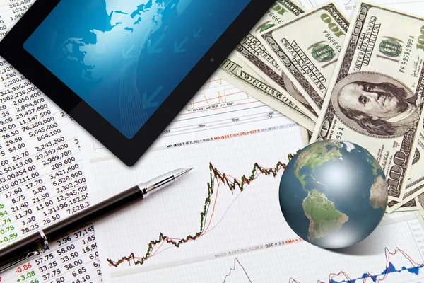 Gráfico de negócios, touchpad, caneta, terra e dólares na mesa — Fotografia de Stock