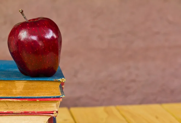 Куча книг с красным яблоком — стоковое фото