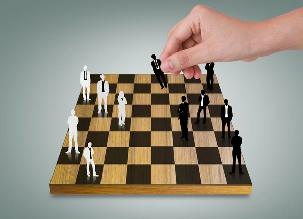 Hand Playing chess game with Silhouettes of business — Stock Photo, Image