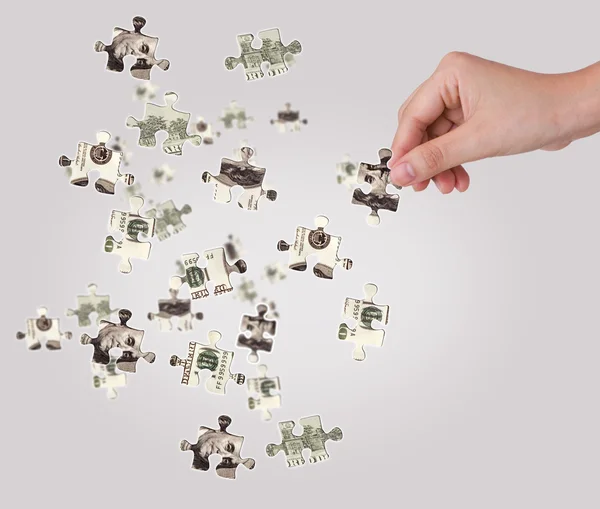 Hands and dollar money puzzle — Stock Photo, Image