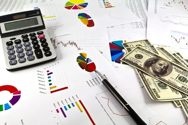 Caneta, calculadora e dólares em gráficos financeiros — Fotografia de Stock