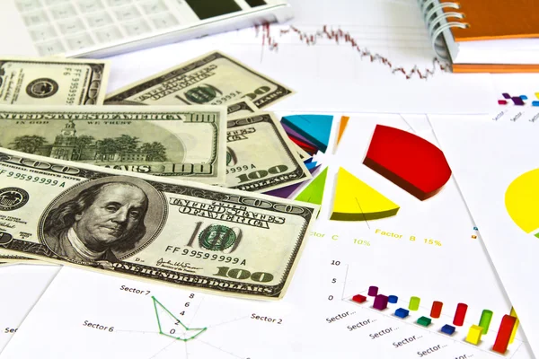 Graf dolů, kalkulačka a dolarů na stole — Stock fotografie