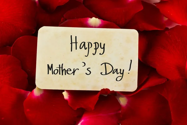 Pétalas de rosa vermelha e cartão velho com palavra "Feliz Dia das Mães  " — Fotografia de Stock