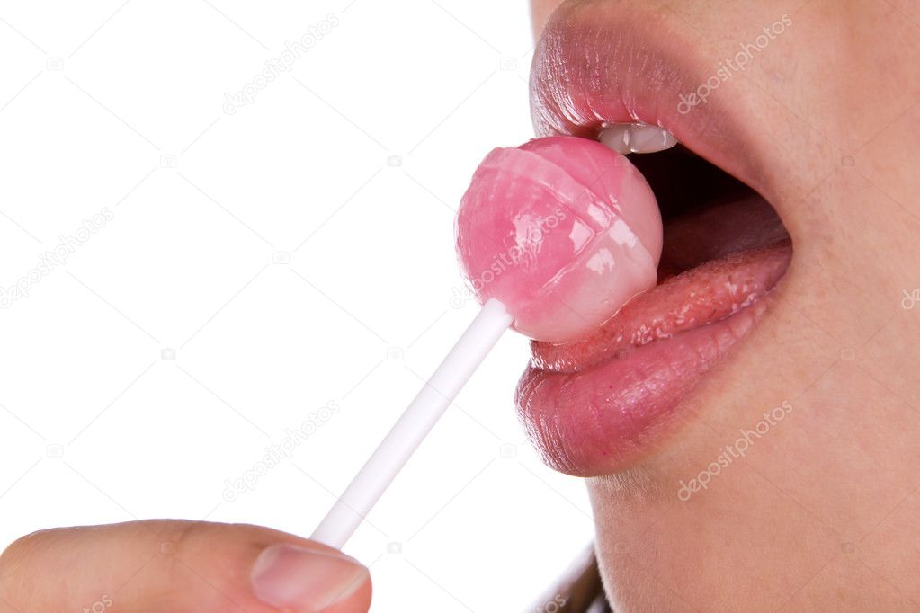 Woman licking a pink shiny lollipop on white background.