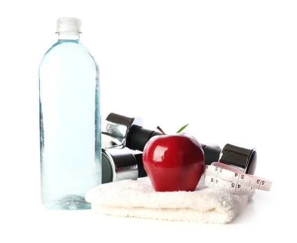 Бутылка воды с весом, яблоко и измерительная лента — стоковое фото