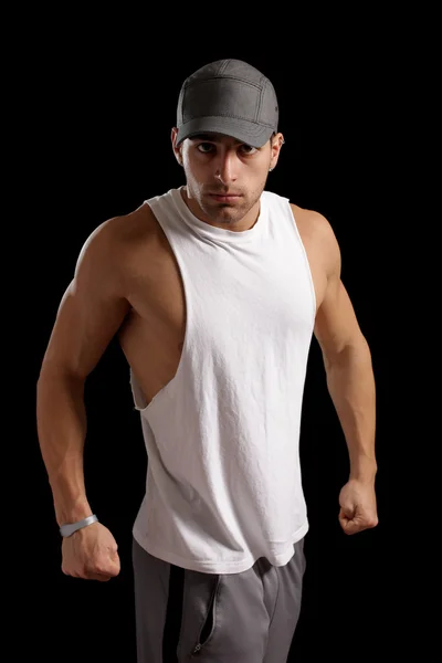 Muscular man in aggressive posture. Studio shot over black. — Stock Photo, Image