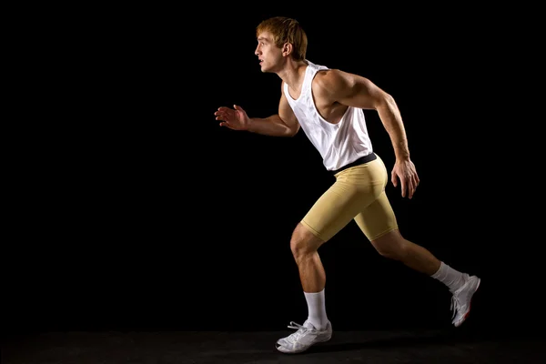 Coureur en mouvement. Studio tourné sur noir . — Photo