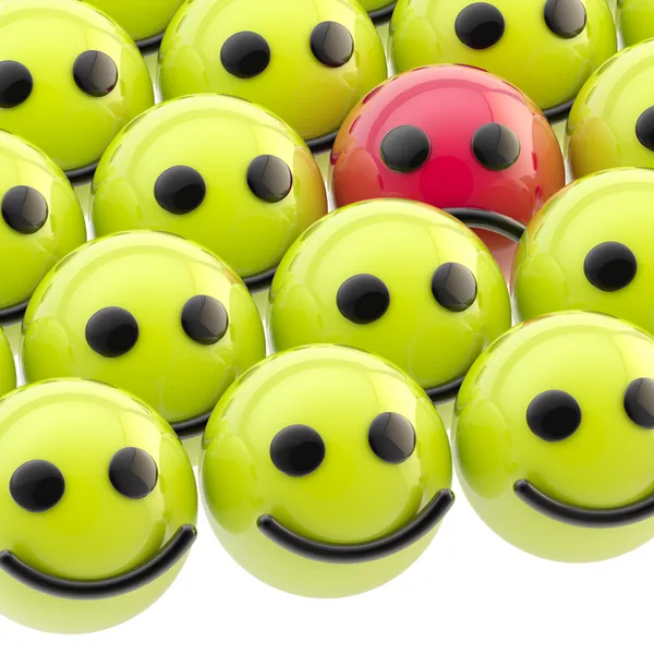 Sad smiley face among happy ones — Stock Photo, Image