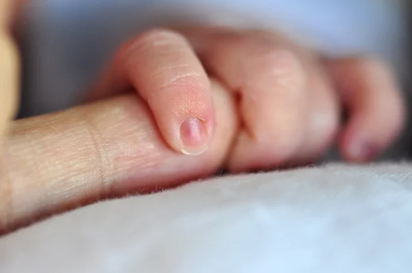 Bebé sosteniendo el dedo del padre — Foto de Stock