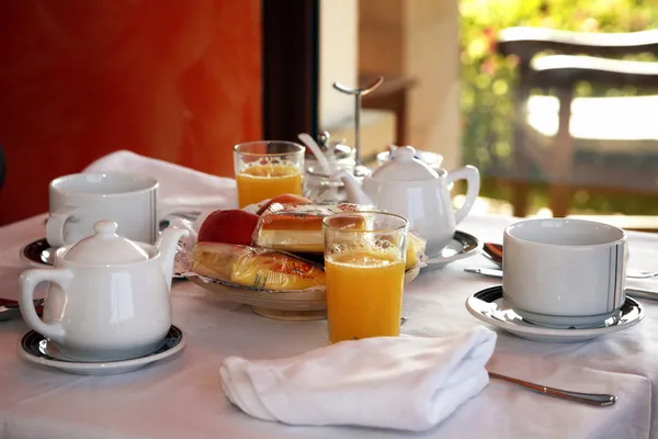 Kontinentales Frühstück mit Orangensaft, Obst und Kaffee lizenzfreie Stockbilder