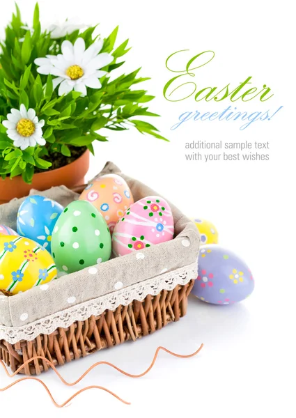 Ovos de Páscoa em cesta com flores de primavera — Fotografia de Stock