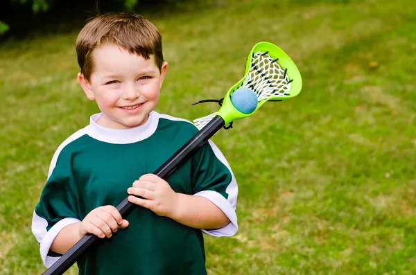 Happy young child lacrosse player with his stick — Stock Photo, Image
