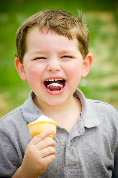 Child laughing while eating ice cream cone — Stock Photo, Image
