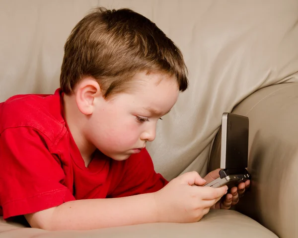 Couch potato conceito de menino jogando videogame enquanto descansa no sofá — Fotografia de Stock