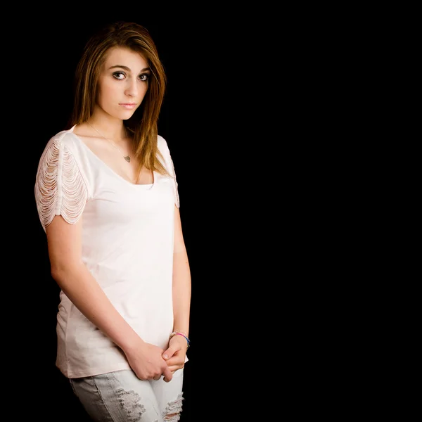 Retrato de bela adolescente com expressão séria isolada em preto com espaço para cópia — Fotografia de Stock