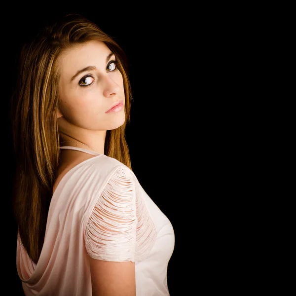 Portrait de belle adolescente avec une expression sérieuse isolé sur noir avec chambre pour copie — Photo