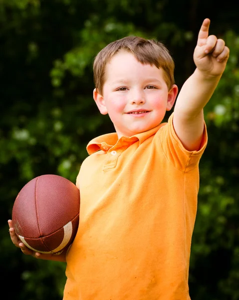 Kind mit Fußball feiert, indem er zeigt, dass er die Nummer 1 ist — Stockfoto