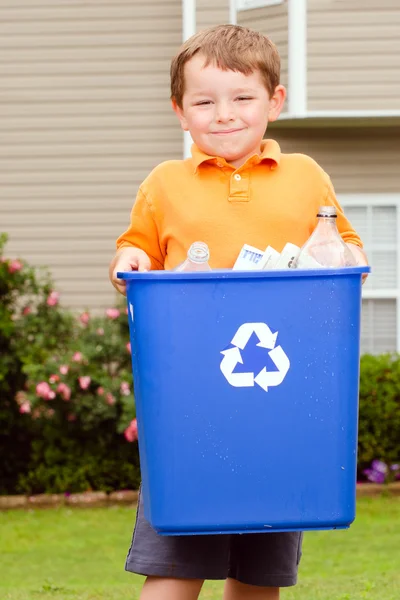 Concept de recyclage avec un jeune enfant portant une poubelle de recyclage au trottoir de sa maison — Photo