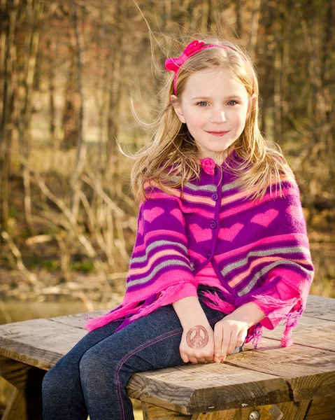 Retrato de invierno o principios de primavera de una niña bonita con poncho de punto en el parque —  Fotos de Stock