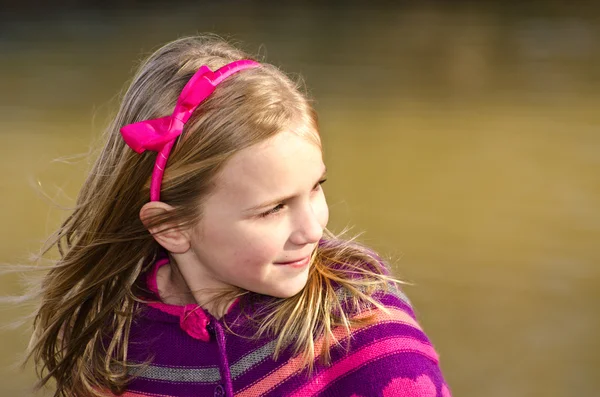 Vinter eller tidig vår porträtt av ganska ung flicka klädd i stickad poncho på park — Stockfoto