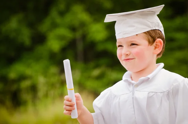 Niño con gorra y bata y certificado para la graduación preescolar — Foto de Stock