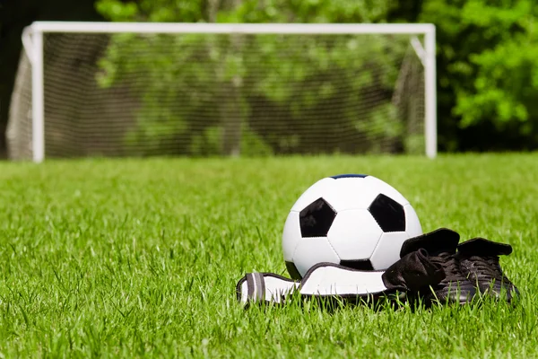 Concepto de deportes infantiles con pelota de fútbol, tacos, espinilleras en el campo con espacio para copiar —  Fotos de Stock