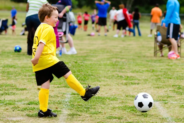 Young child boy playing soccer during organized league game — Stock Photo, Image