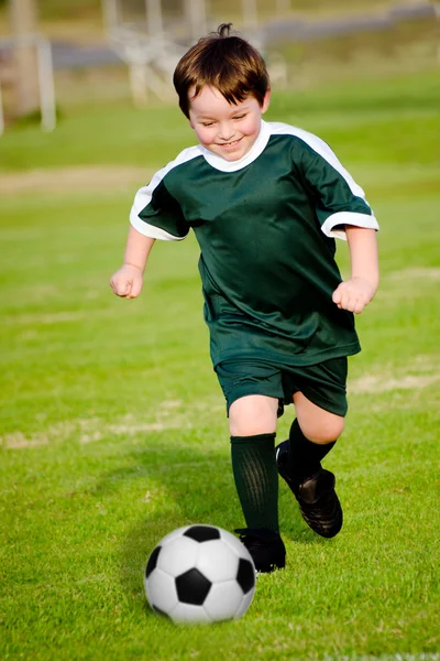 Młody chłopak grać w piłkę nożną w zorganizowana Liga gra — Zdjęcie stockowe