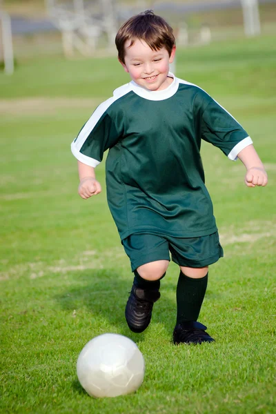 Young boy playing soccer in organized league game — Stock Photo, Image