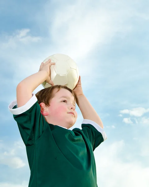 Mladý chlapec hrát fotbal v organizovaného fotbalu — Stock fotografie
