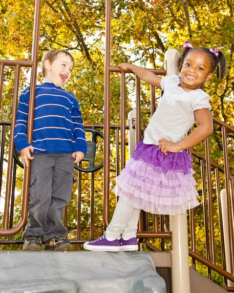 Fiatal afro-amerikai lány és egy fiatal fehér fiú játszik együtt, park — Stock Fotó