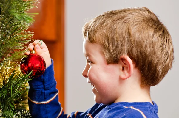 Joven niño decora árbol de Navidad para vacaciones . — Foto de Stock