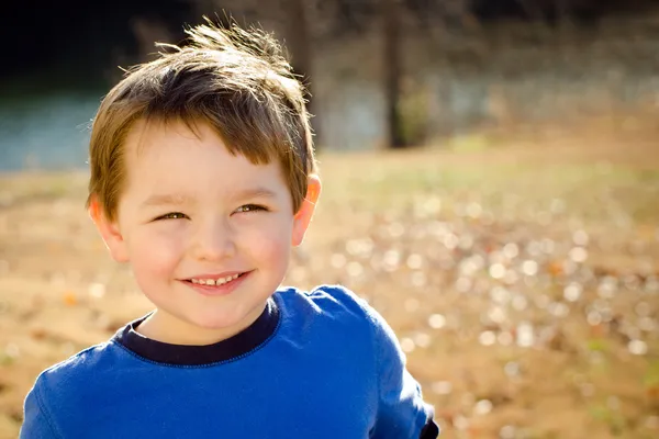 Porträtt av glad ung pojke utomhus i bild med kopia utrymme — Stockfoto
