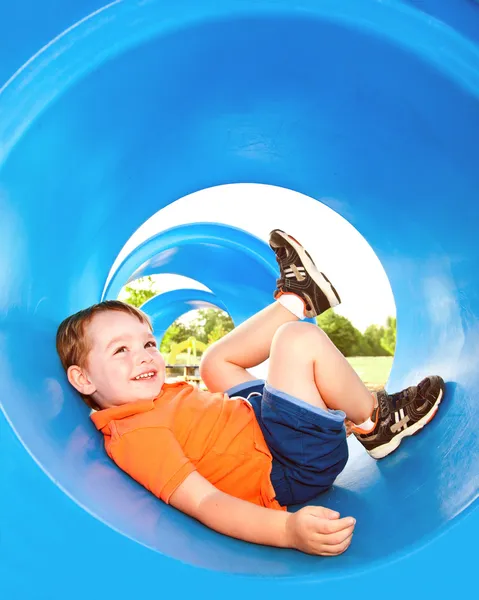 Bonito menino ou criança brincando em um túnel no playground . — Fotografia de Stock