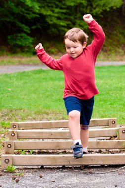 Young boy on playground during spring. clipart