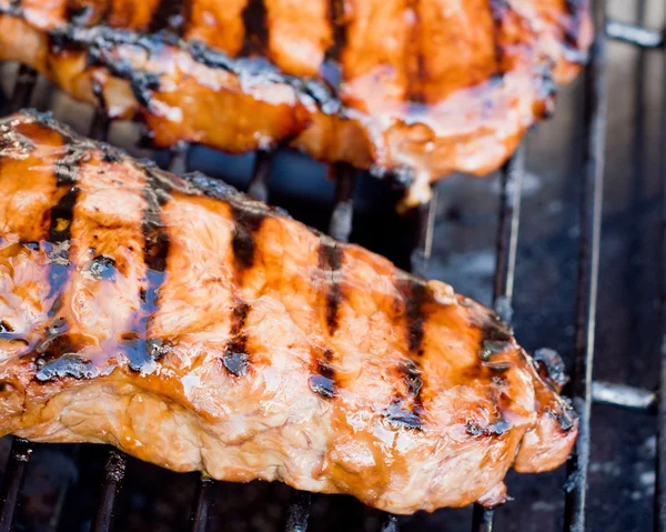 stock image Juicy New York strip steak on a gas grill.