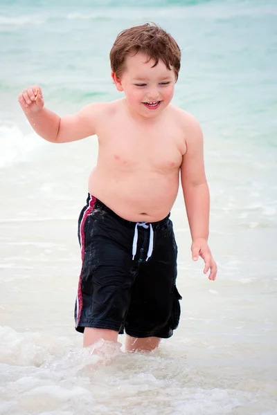 ビーチでのサーフィンで遊んでいる若い少年 — ストック写真