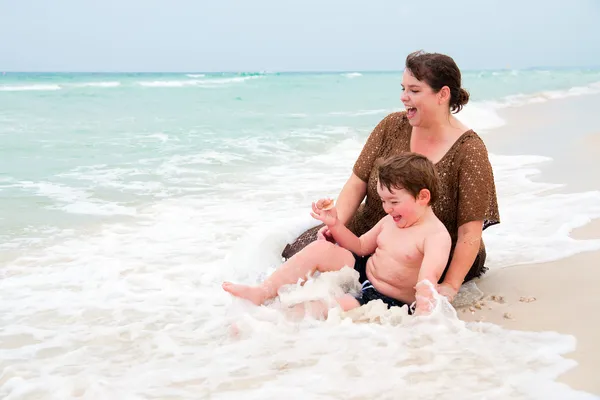 Mutter und Sohn spielen am Strand in der Brandung — Stockfoto