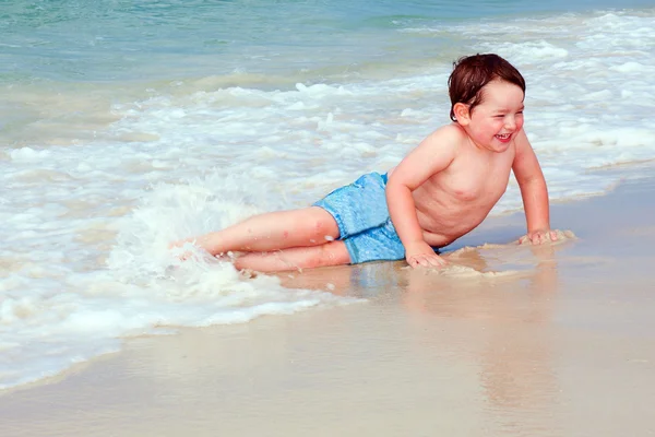 Junge spielt am Strand in der Brandung — Stockfoto