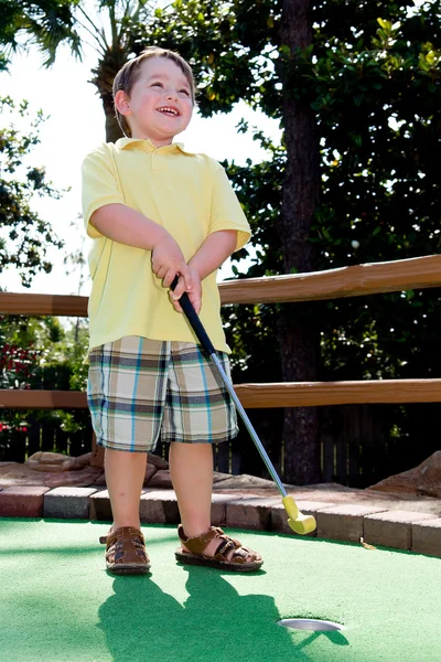 Genç çocuk mini golf putt putt sahasında oynuyor.. — Stok fotoğraf