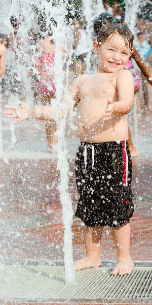 Happy νεαρό αγόρι ή το παιδί έχει διασκέδαση παίζοντας σε πηγές νερού στο εκατονταετές Ολυμπιακό Πάρκο στην Ατλάντα, γεωργία, από ζεστό ημέρα κατά τη διάρκεια του καλοκαιριού. — Φωτογραφία Αρχείου