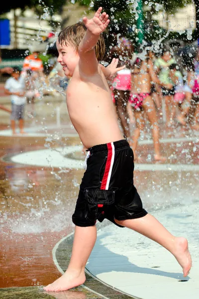 Gelukkige jongen of kind heeft plezier spelen in water fonteinen in het centennial olympic park in atlanta, georgia, aan hete dag tijdens de zomer. — Stockfoto