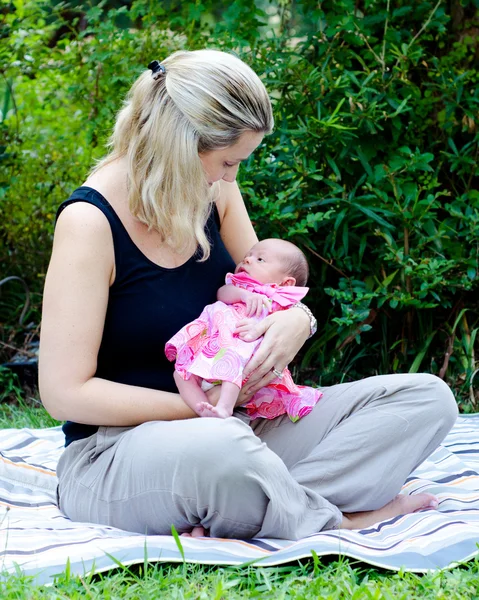 Porträtt av glad mamma och blandras nyfödd baby flicka utomhus på park — Stockfoto