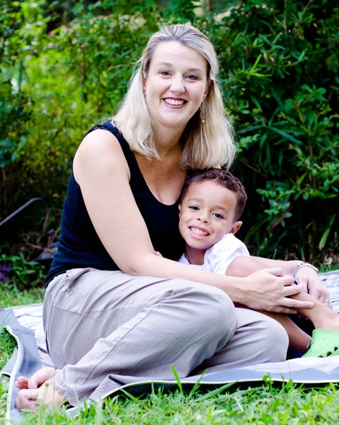 Porträtt av lycklig mor och blandad ras son utomhus på park — Stockfoto