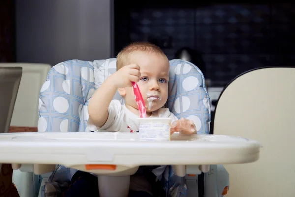 Мальчик ест йогуртовый крем — стоковое фото