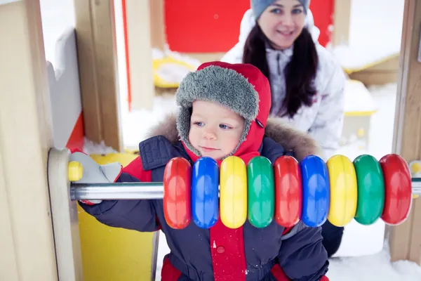 Bébé garçon sur une aire de jeux d'hiver — Photo