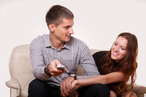 Mladý pár, tvrdí přes dálkové ovládání televizoru — Stock fotografie