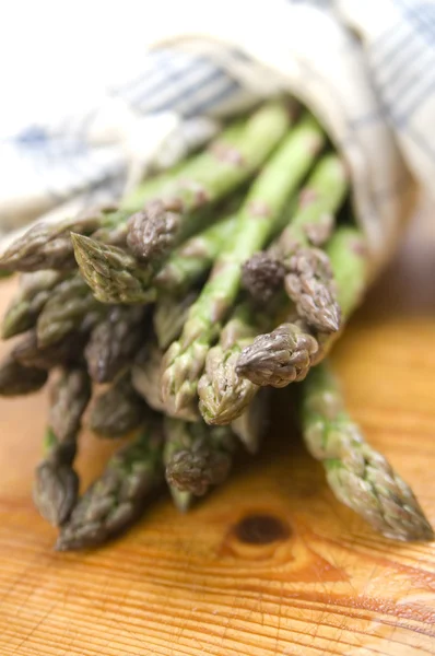 Mazzo di asparagi freschi su fondo legno — Foto Stock